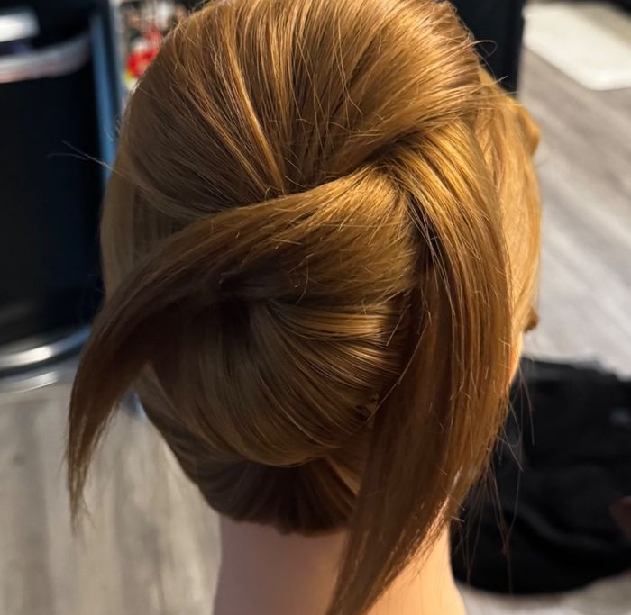 Sleek twisted chignon updo by Yiqara Hair Co.