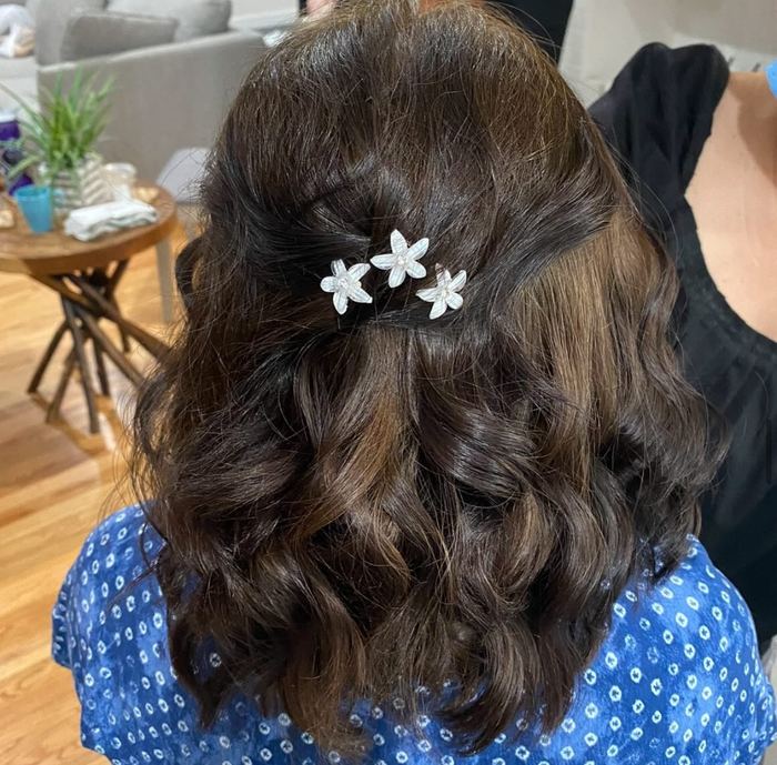 Half-up hairstyle with floral hair clips for a special event